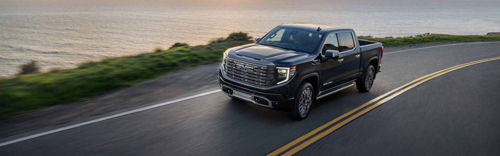 2025 GMC Hummer EV Pickup driving on a two lane road