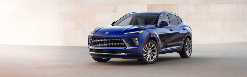 A blue Buick Encore GX parked in front of a light-colored wall.